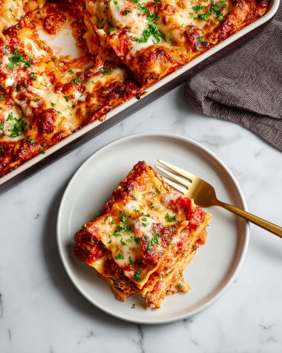 The image shows a serving of lasagna on a white plate, with a golden fork resting beside it. The lasagna slice has several layers: a bottom light brown pasta layer, a middle reddish tomato sauce layer with chunks of tomato, and melted creamy white cheese on top with green parsley sprinkled over it. To the side, there is a white baking tray filled with more lasagna, showing similar layers and topped with browned melted cheese and green parsley. The whole scene is set on a white marbled surface, highlighting the colors of the dish clearly. Photo taken with an iphone --ar 4:5 --v 7