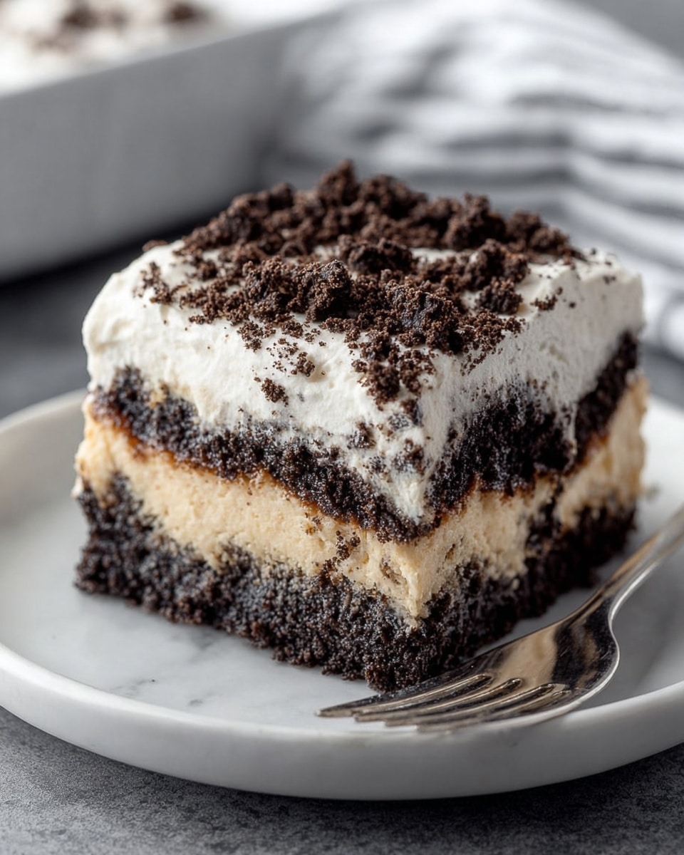 A square piece of layered dessert sits on a white plate with a silver fork beside it. The bottom layer is dark and crumbly, looking like crushed chocolate cookies. Above it is a creamy light beige layer, smooth in texture. The next layer is again dark and dense with cookie crumbs mixed in. The top is a thick layer of white cream, soft and swirled, sprinkled generously with dark chocolate cookie crumbs. The background shows a white marbled texture with blurred soft white and gray stripes. photo taken with an iphone --ar 4:5 --v 7
