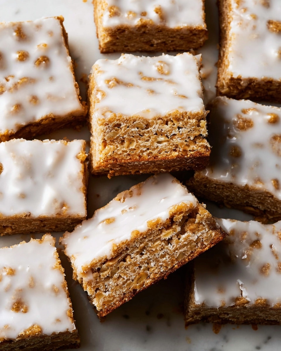 The image shows a close-up of nine square cookie bars arranged in a 3x3 grid on a white marbled surface. Each bar has two visible layers: the bottom layer is a golden-brown baked cookie base with a slightly crumbly texture, while the top layer is a smooth, glossy white icing with a few small holes and uneven spots showing the cookie beneath. The cookie edges are slightly rough and crumbly, and the icing covers almost the entire top surface of each piece. Photo taken with an iphone --ar 4:5 --v 7