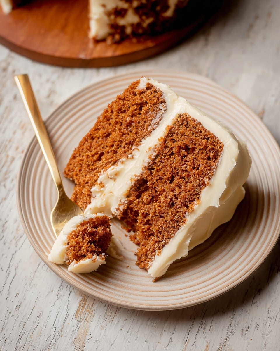 A slice of two-layer brown cake with a moist and crumbly texture sits on a white plate with subtle circular ridges. Between the two cake layers is a creamy white frosting, thick and smooth, matching a generous layer of frosting spreading slightly over the side of the cake. A gold-colored fork with a bite of cake and frosting rests on the plate close to the slice. The scene is set on a white marbled textured surface that adds a clean and soft backdrop. Photo taken with an iphone --ar 4:5 --v 7