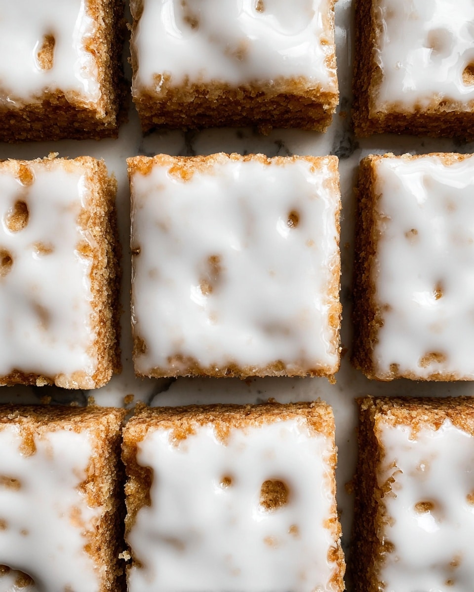 The image shows several square bars layered with a crumbly, golden-brown base that looks dense and textured, possibly made from oats or nuts. Each square is topped with a smooth, white glaze that covers most of the surface but allows parts of the base to peek through in irregular patches. The bars are stacked and spread closely together on a white marbled surface, highlighting their rich texture and the contrast between the base and the shiny icing. One bar is slightly lifted, showing the thickness and layered look clearly. photo taken with an iphone --ar 4:5 --v 7