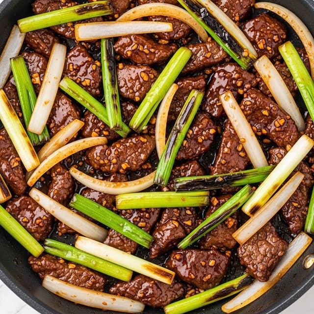 The image shows a close-up of a stir fry dish cooking in a dark pan, filled with several layers of glossy, thinly sliced brown beef pieces evenly coated in a rich dark sauce. Mixed among the beef are bright green, slightly shiny stalks of green onions cut into long pieces, and translucent thick slices of white onions with a slight golden tint. The textures vary from smooth and saucy beef to the crisp, fresh look of the green onions and the soft, cooked onions. The colors are mainly dark brown and green, with some light beige from the onions, all blending under the shiny sauce. photo taken with an iphone --ar 4:5 --v 7