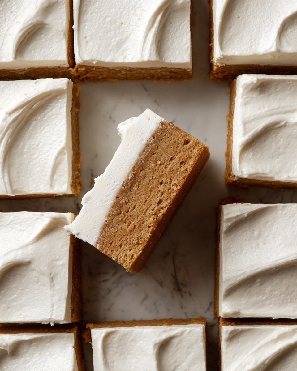 The image shows several square pieces of dessert arranged closely on a white marbled surface. Each piece has two distinct layers: the bottom layer is thick, dense, and light brown with a slightly coarse texture, resembling a baked or firm base; the top layer is creamy white, smooth, and evenly spread, making up about half of the piece's height. The top surface of the dessert is flat and shows subtle, fine lines, indicating careful slicing. The lighting highlights the creaminess of the top layer and the solid texture of the bottom layer very clearly. Photo taken with an iphone --ar 4:5 --v 7