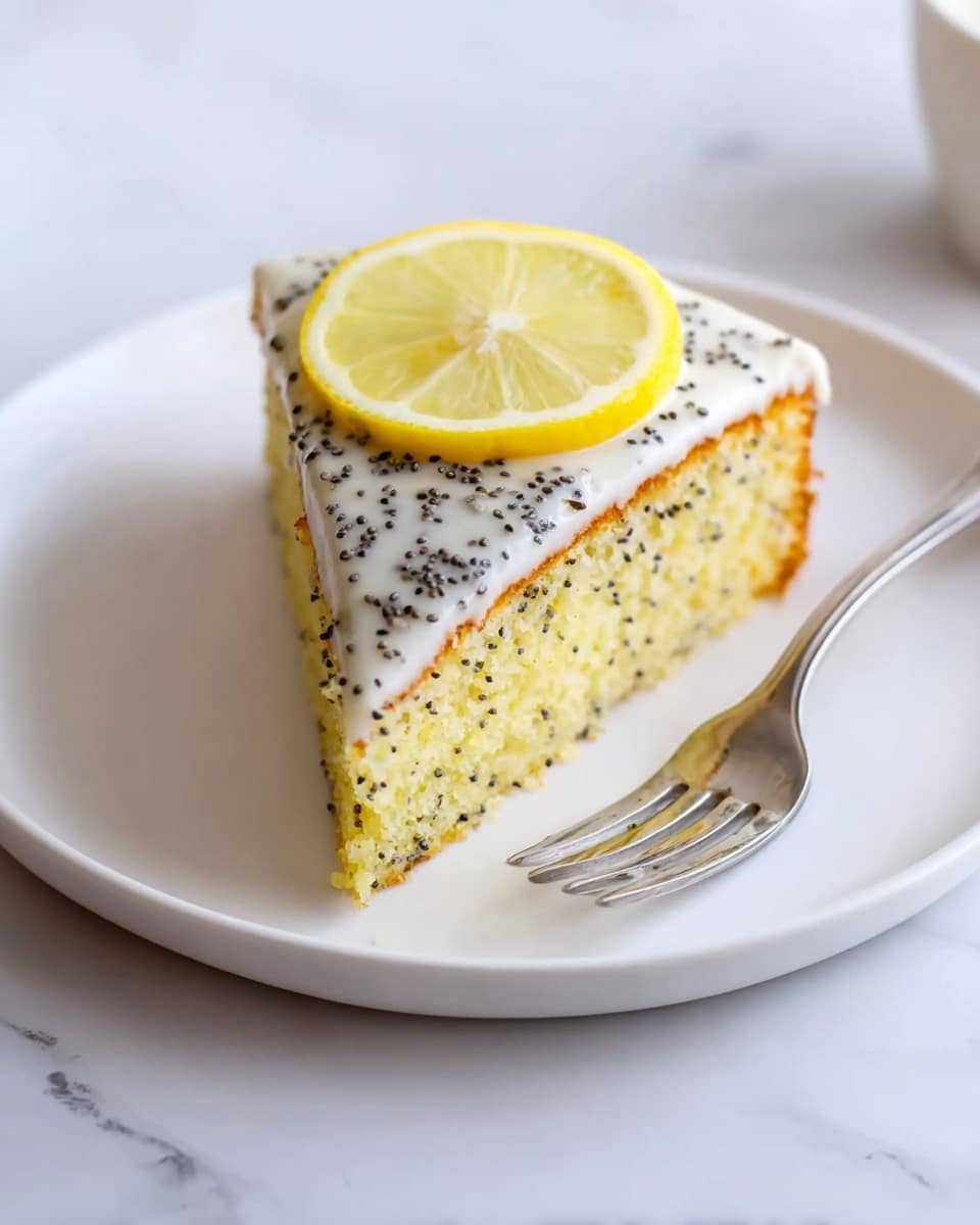 A single slice of lemon poppy seed cake is placed on a white plate over a white marbled surface. The slice has two layers: a soft light yellow cake base studded with small black poppy seeds, and a smooth white icing layer on top sprinkled evenly with more black poppy seeds. A thin round slice of lemon rests on the icing, adding a fresh yellow contrast. A silver fork lies to the right side of the plate. The scene is bright and clean. photo taken with an iphone --ar 4:5 --v 7